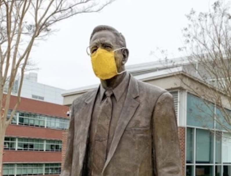 A statue of Henry Rowan wearing a face mask