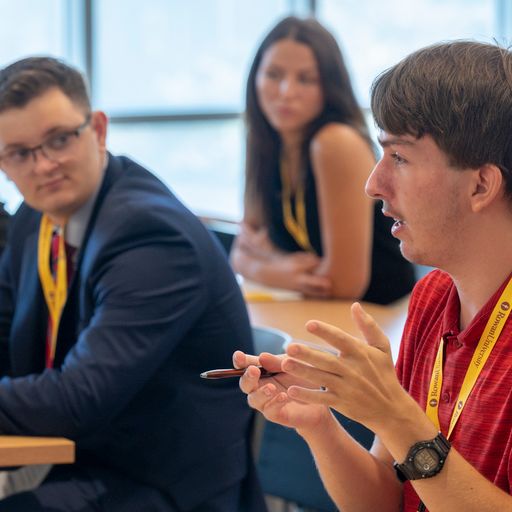 Students asking a question at a panel discussion